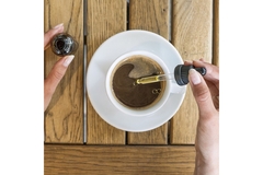 Image A women puts CBD oil into her coffee.